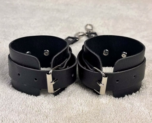 Regulowane kajdanki na ręce w kolorze czarnym. Miękki materiał, metalowe zapięcia, wygodne dopasowanie. Obwód 17,5–27,5 cm. Dyskretny i komfortowy model.