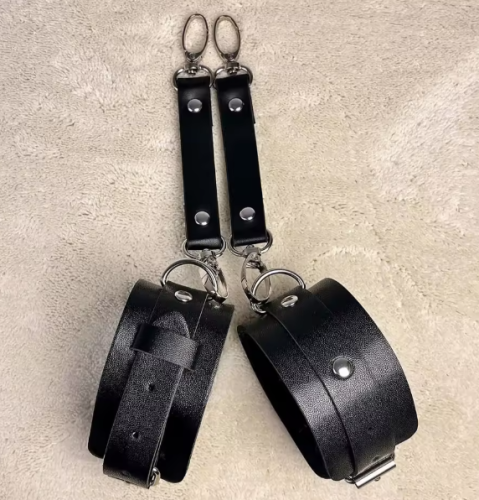 Regulowane kajdanki na ręce w kolorze czarnym. Miękki materiał, metalowe zapięcia, wygodne dopasowanie. Obwód 17,5–27,5 cm. Dyskretny i komfortowy model.