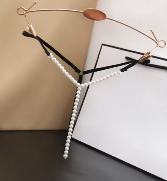 Zestaw 3 par stringów z perełkami w kolorze czarnym, różowym i białym. Regulowane paseczki, fason Y-string i elastyczny obwód 56–90 cm.